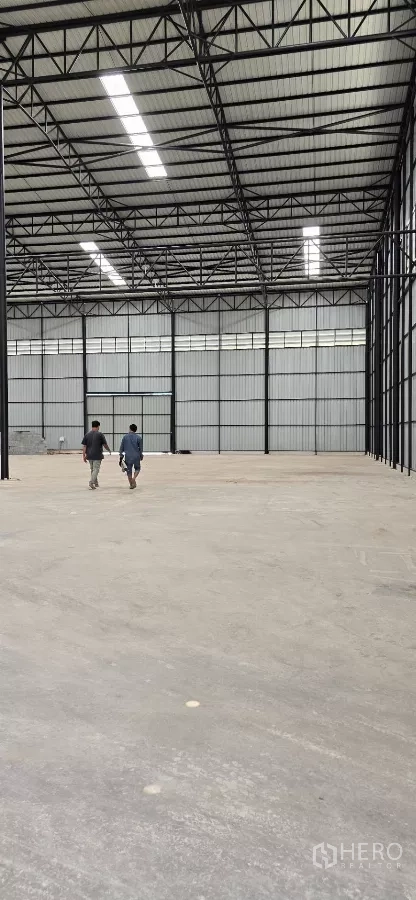 工厂 出租在Mueang Samut Sakhon, Samut Sakhon - 从厂房大厅深处望向大型出入口，展示开阔的作业空间。
