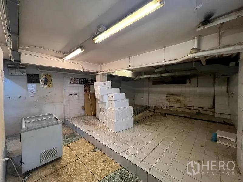 店屋 出售在Bang Rak, Bangkok - 铺满瓷砖的后勤房，日光灯顶，堆放白色箱子。