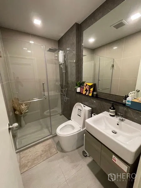 คอนโด ขาย - ห้องน้ำที่สอง พร้อมตู้กระจกอาบน้ำ โถสุขภัณฑ์ และตู้ใต้อ่างล้างหน้า