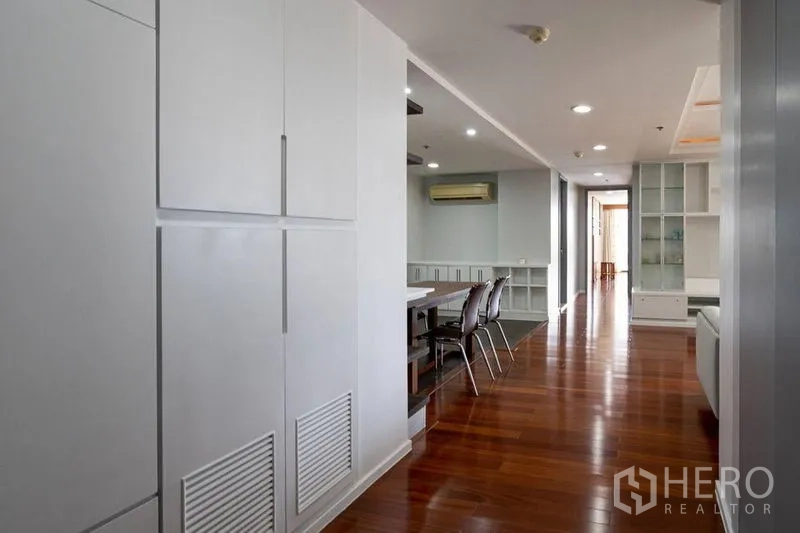 公寓 出售在Watthana, Bangkok - 走廊通往餐厅与客厅，带内置柜与光亮木地板。