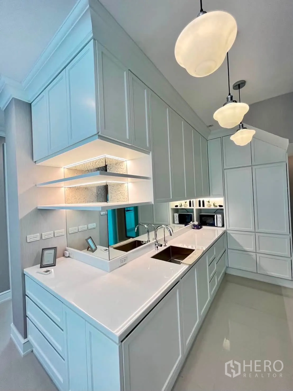 Townhouse for rent in Lat Phrao, Bangkok - Alternate view of the main kitchen showing long counters and pendant lighting.