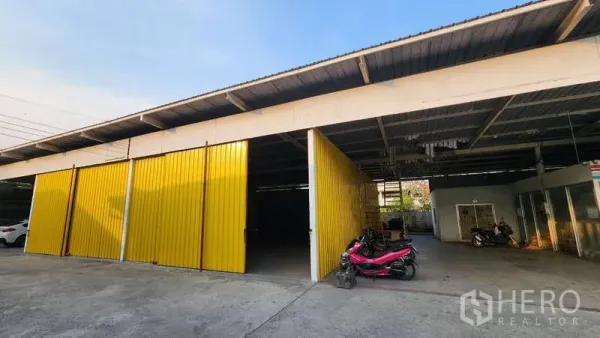 货栈 出租在Bang Khen, Bangkok - 带顶装卸区，黄色大门开启，前方设有停车区。