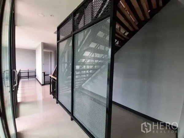 工厂 出租或出售 - 工业风楼梯，金属网隔断与亮面地砖。