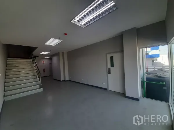 Factory for rent in Bang Lamung, Chon Buri - Office landing with stairwell, large windows and smooth epoxy flooring.