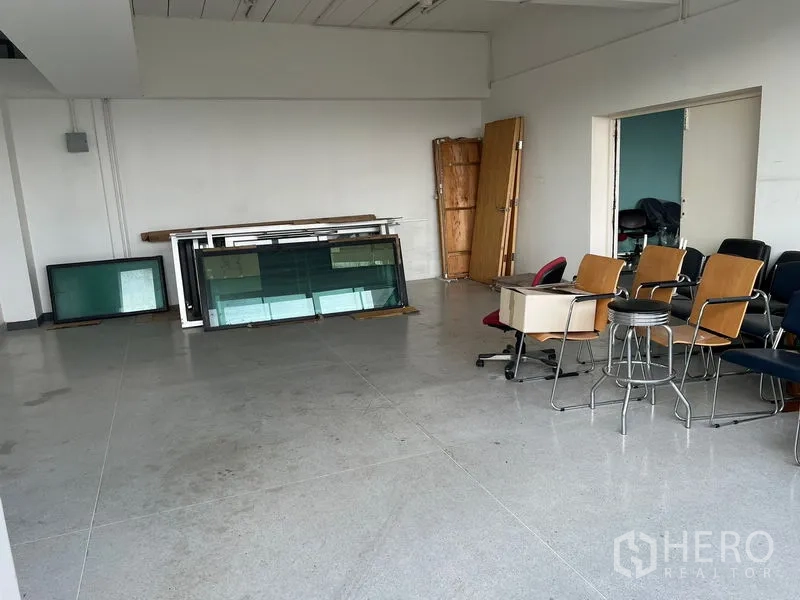 Office Space for rent in Mueang Samut Prakan, Samut Prakan - Storage-style room with stacked chairs and glass panels awaiting fit-out.
