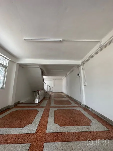 อาคารพาณิชย์ ให้เช่าในBangkok - ชั้นเปิดโล่งทรงยาว มีโคมไฟเพดานและทางขึ้นบันได.