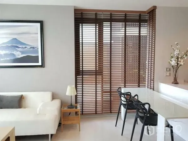 คอนโด ให้เช่าหรือขายในKhlong Toei, Bangkok - มุมรับประทานอาหารข้างหน้าต่างบานสูงแบบม่านไม้ คู่กับโซฟาสีขาวและงานศิลป์