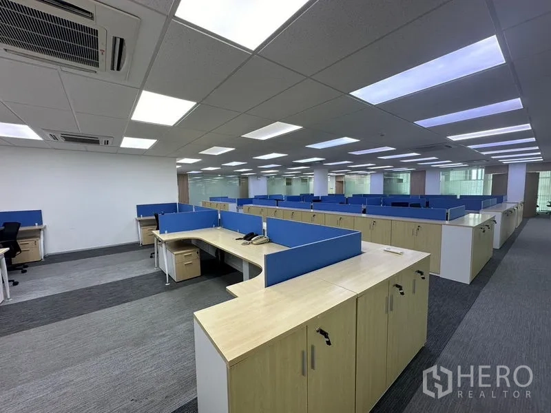 Office Space for rent - Wide view of furnished office area with multiple workstation pods and acoustic ceiling panels.