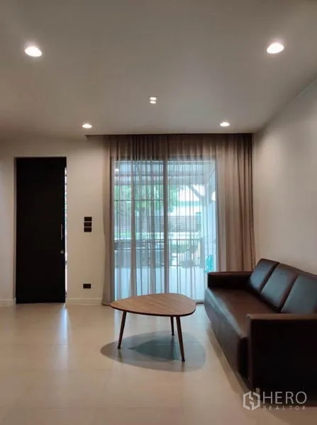 ทาวน์เฮาส์ ให้เช่าในSuan Luang, Bangkok - ห้องนั่งเล่นสว่าง โซฟา โต๊ะกลาง และผ้าม่านสูงจรดเพดาน