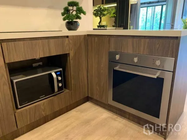 Condominium for rent - Built-in kitchen corner featuring a stainless oven, microwave niche and bonsai decoration on the counter.
