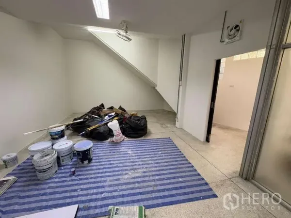 独立商业地产 出租在Khlong Toei, Bangkok - 楼梯下的底层房间在翻新，放置油漆桶与工具。