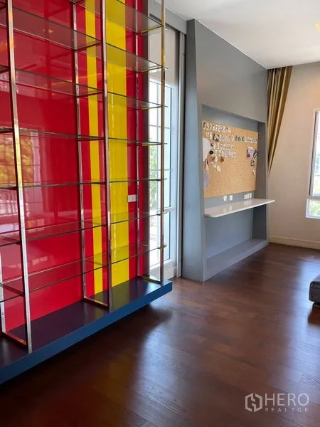 独立式住宅 出租在Bang Phli, Samut Prakan - 红黄相间展示架，旁为学习角与软木公告板