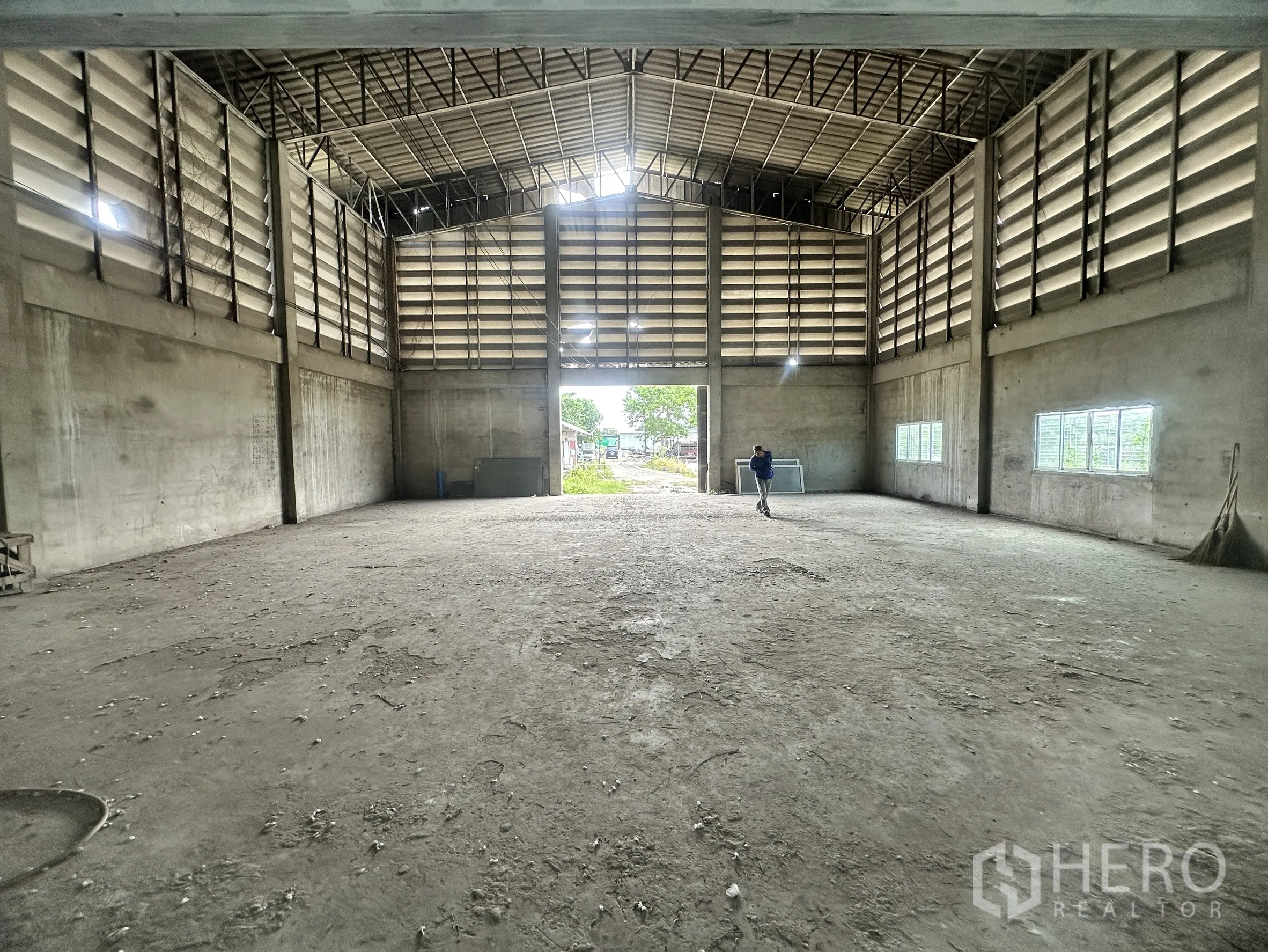 Land for sale in Mueang Samut Prakan, Samut Prakan - Open warehouse hall with wide entrance and multiple windows along concrete walls.