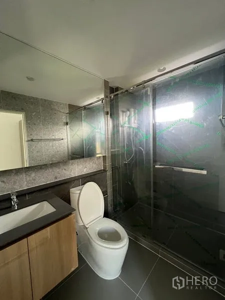 Detached House for rent in Bang Kapi, Bangkok - Modern bathroom with glass shower enclosure, large mirror and vanity.