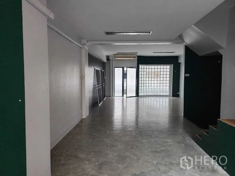 店屋 出租在Khlong Toei, Bangkok - 宽敞的一层商铺空间，水泥地面与玻璃砖墙，前门可见。