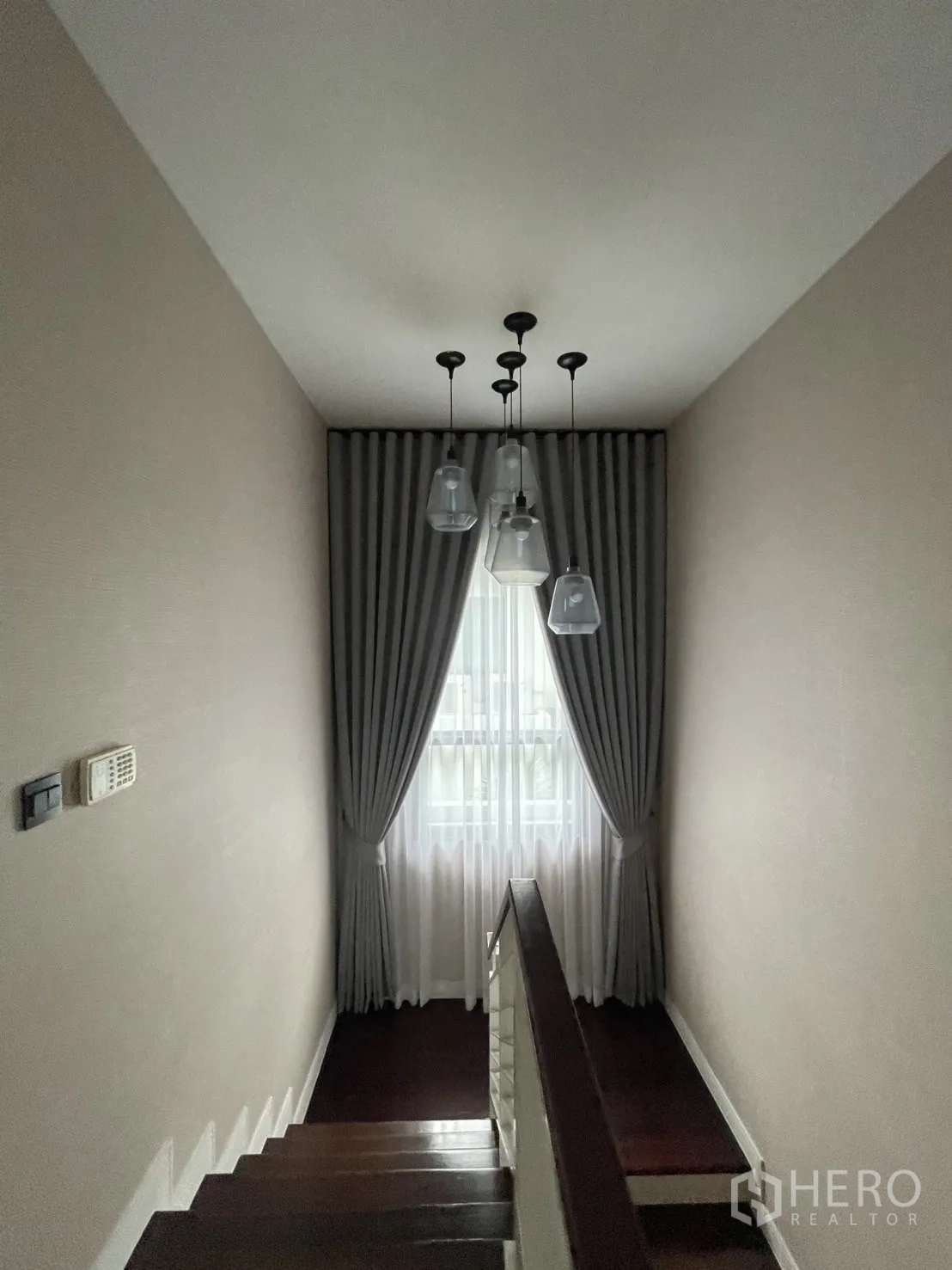 Detached House for rent in Bang Kapi, Bangkok - Staircase with pendant lights and tall curtained window.