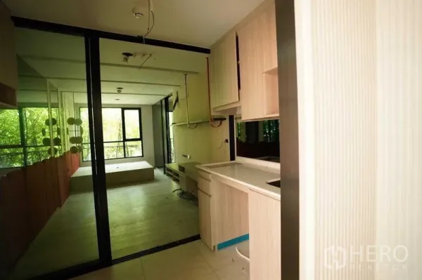 独立商业地产 出租在Bang Na, Bangkok - 浅木色橱柜的小型茶水间与玻璃隔断工作区。