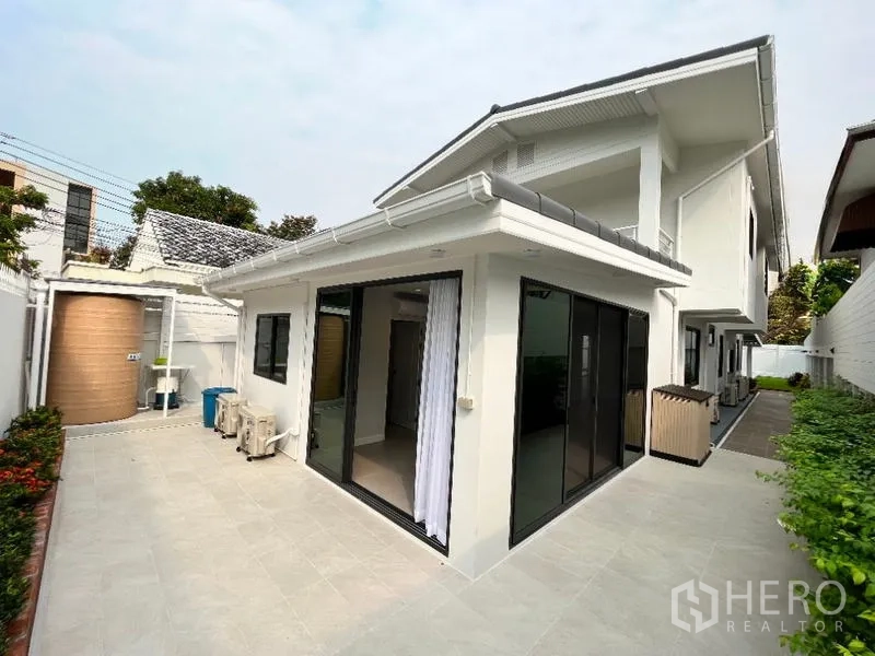 独立式住宅 出租在Phaya Thai, Bangkok - 后院露台，推拉玻璃门、瓷砖地面与水塔。