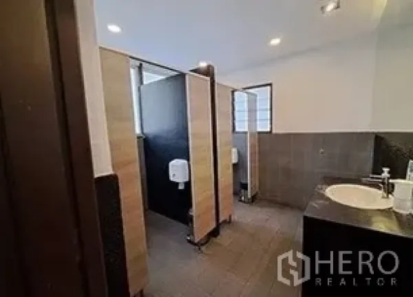 零售空间 出租在Bangkok - 卫生间区域配有多个隔间、瓷砖墙面和洗手台。