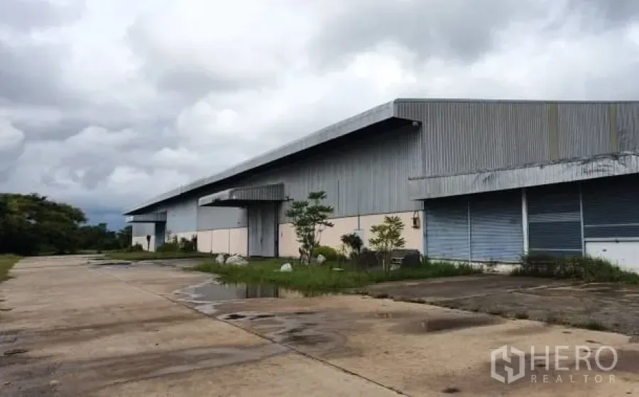 คลังสินค้า ให้เช่าในChaloem Phra Kiat, Nakhon Ratchasima - อาคารโกดังโลหะขนาดใหญ่ หลังคาที่ยาว พื้นคอนกรีตกว้างและท่าโหลด ใต้ท้องฟ้าครึ้ม