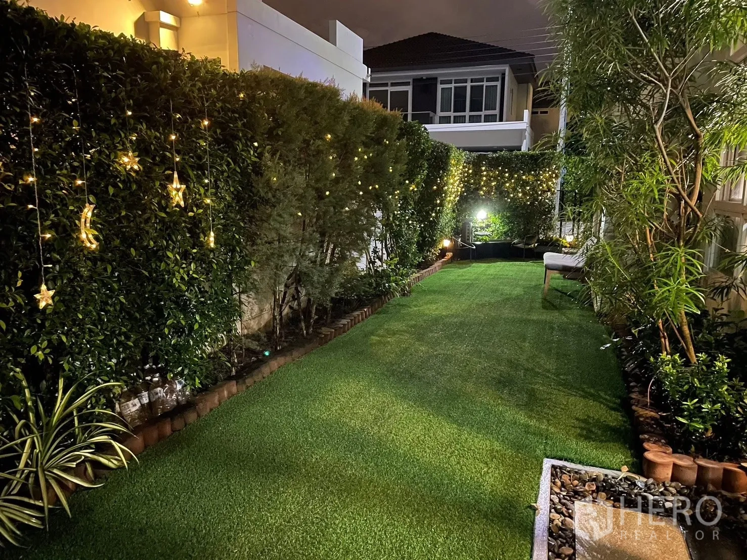 Detached House for rent or sale in Bang Phli, Samut Prakan - Long private backyard with artificial grass, hedges, and warm fairy lights.