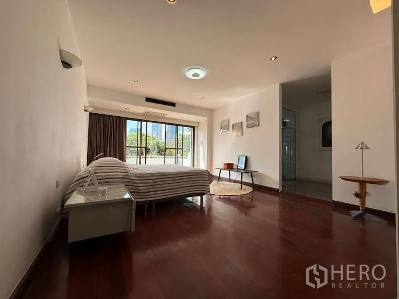 ทาวน์เฮาส์ ให้เช่าในKhlong Toei, Bangkok - ห้องนอนมาสเตอร์กว้าง พื้นไม้ และประตูกระจกออกระเบียง