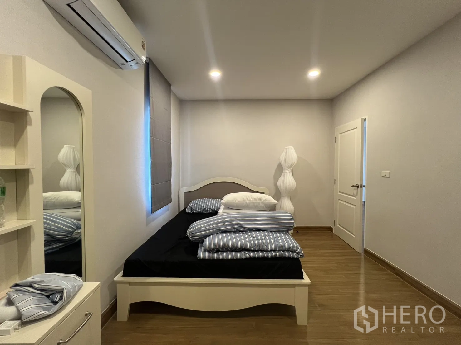 Detached House for rent in Lat Krabang, Bangkok - Bedroom angle with bed, bedside lamp, and white door.