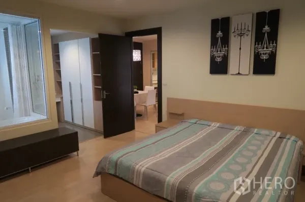 Condominium for rent in Huai Khwang, Bangkok - Master bedroom view to dressing area with wardrobes and glass window looking into the bathroom.