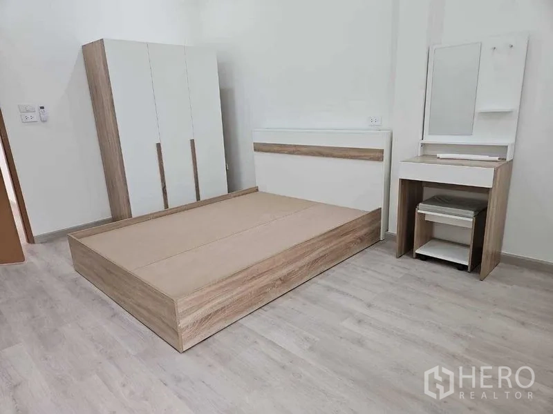 Townhouse for rent in Khlong Toei, Bangkok - Second bedroom with wood platform bed, wardrobe and vanity set.