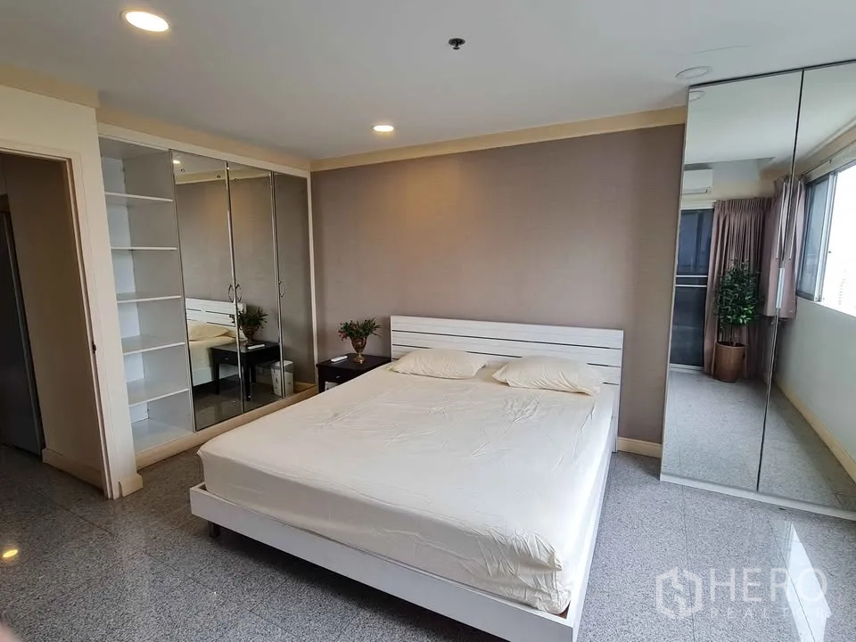 Condominium for rent in Khlong Toei, Bangkok - Dining area with four-seat table, artwork and display shelves.