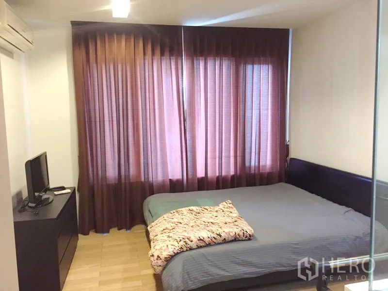 คอนโด ให้เช่าในKhlong Toei, Bangkok - ห้องนอนอบอุ่น เตียงขนาดใหญ่ ม่านทึบแสง และทีวีบนตู้ลิ้นชัก