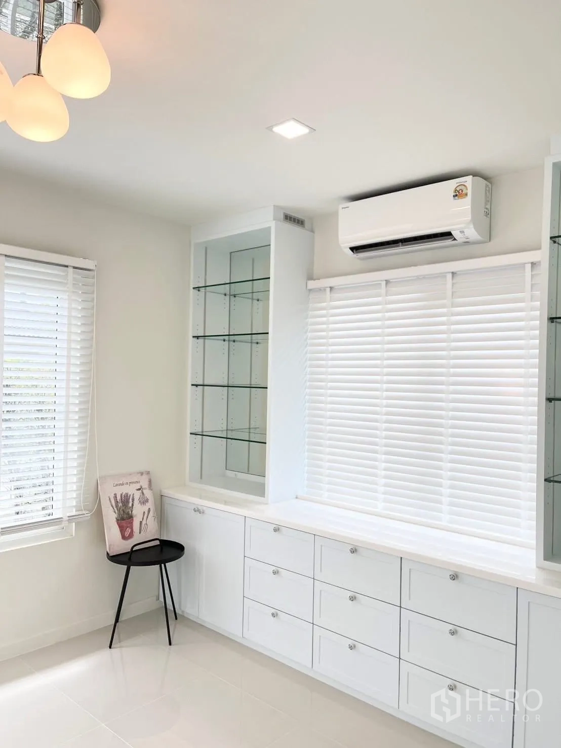 Detached House for rent in Bang Phli, Samut Prakan - Built-in white storage with glass display shelves under a wall air conditioner.