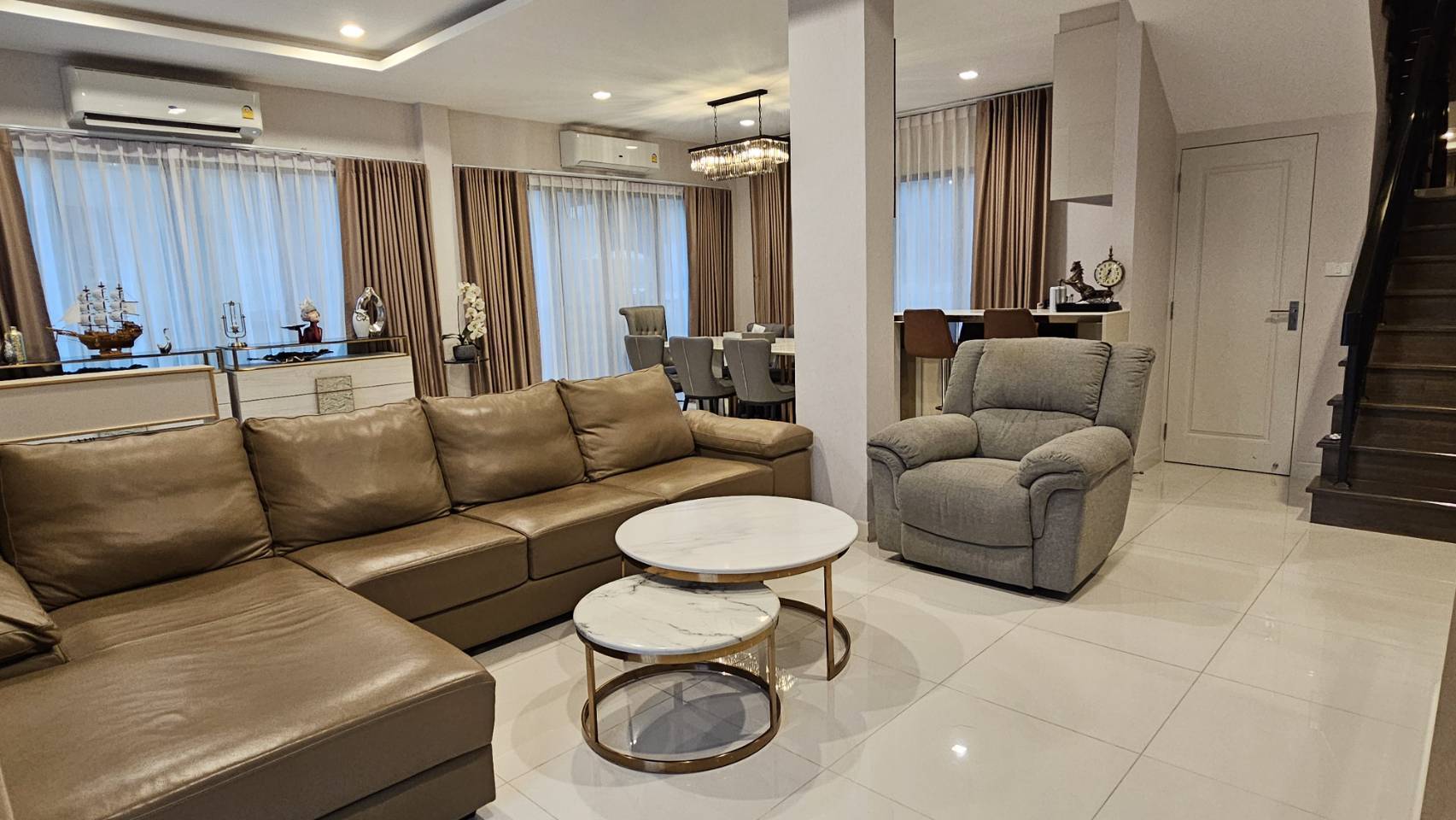Detached House for rent in Saphan Sung, Bangkok - Bright living room with sectional sofa, recliner and dining area beyond.