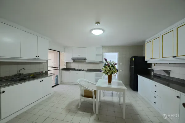 公寓 出租或出售在Watthana, Bangkok - 宽敞独立厨房，白色橱柜，花岗岩台面，燃气灶与餐桌