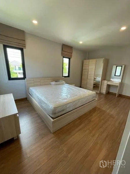 Detached House for rent in Don Mueang, Bangkok - Spacious secondary bedroom with large bed, wardrobes and multiple windows.