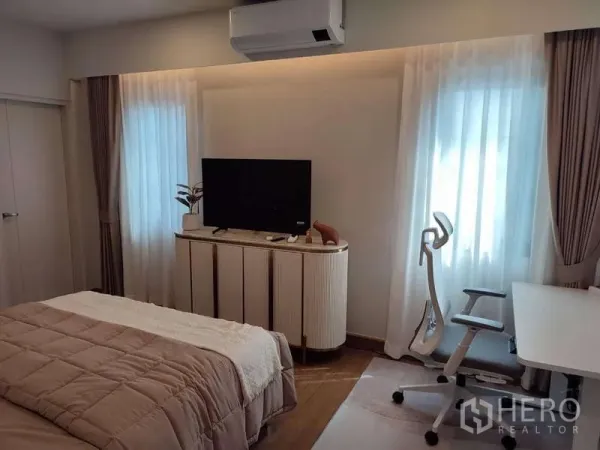 Detached House for rent in Bang Phli, Samut Prakan - Bright bedroom with TV console, work desk, ergonomic chair, sheer curtains and air conditioning.