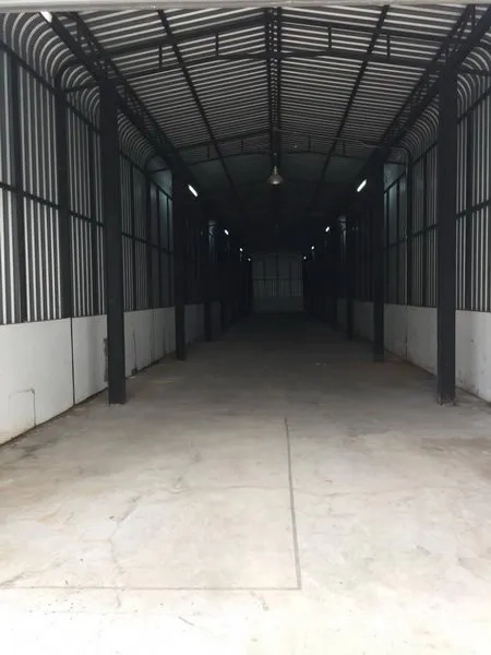 Home Office for rent or sale in Wang Thonglang, Bangkok - Long warehouse interior with arched steel roof, lighting and concrete floor.