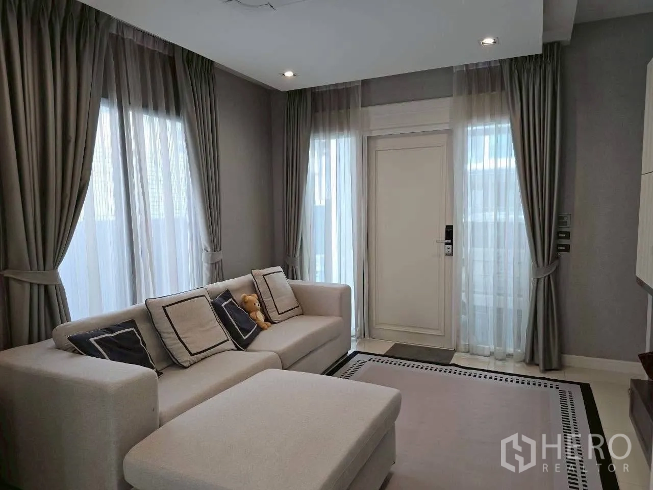 ทาวน์เฮาส์ ให้เช่าหรือขายในLat Phrao, Bangkok - ห้องรับแขกสว่าง โซฟาตัวแอล ประตูทางเข้า และม่านโปร่ง