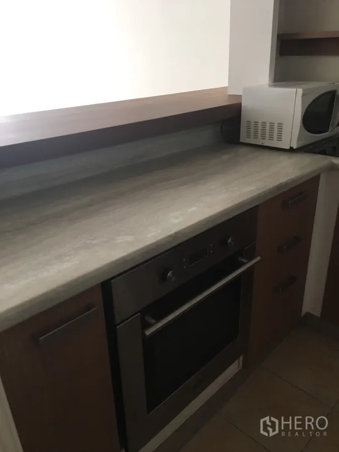 คอนโด ให้เช่าในWatthana, Bangkok - ห้องครัวขนาดกะทัดรัด เคาน์เตอร์หิน เตาอบบิวต์อิน และตู้ไม้