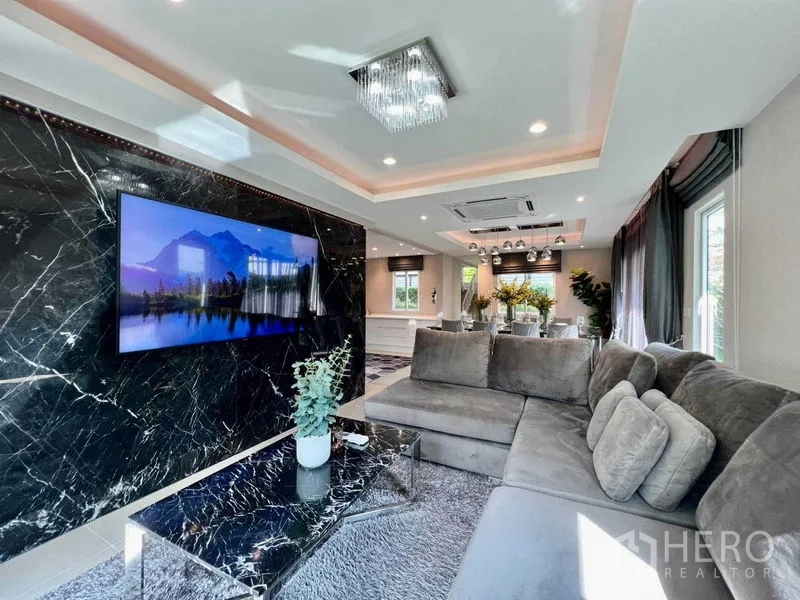 บ้าน ขายในBang Sao Thong, Samut Prakan - ห้องนั่งเล่นอบอุ่น โซฟาตัวแอล โต๊ะกลางหินอ่อน โคมไฟคริสตัล และทีวีจอใหญ่