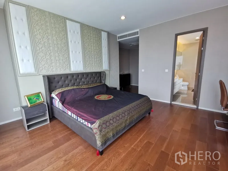 Condominium for rent in Bang Kho Laem, Bangkok - Master bedroom with padded feature wall and entrance to the ensuite bathroom.