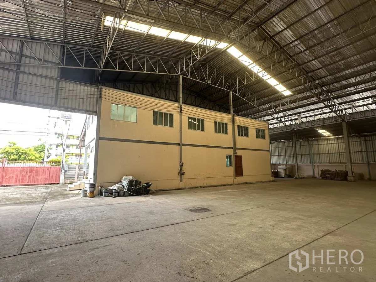 Factory for rent in Pathum Thani - Internal two-storey office block beneath the tall warehouse roof with broad access opening to the yard.