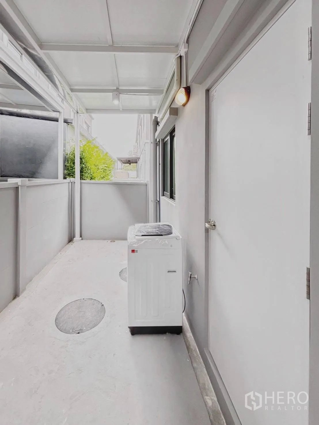 ทาวน์เฮาส์ for rent in Bang Phli, Samut Prakan - พื้นที่ซักล้างหลังบ้านมุงหลังคาพร้อมเครื่องซักผ้าและประตูทางออก.