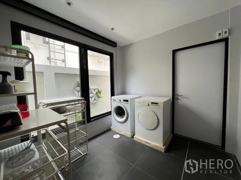 联排别墅 出租在Saphan Sung, Bangkok - 洗衣房配洗衣机、烘干机、置物架与大窗。