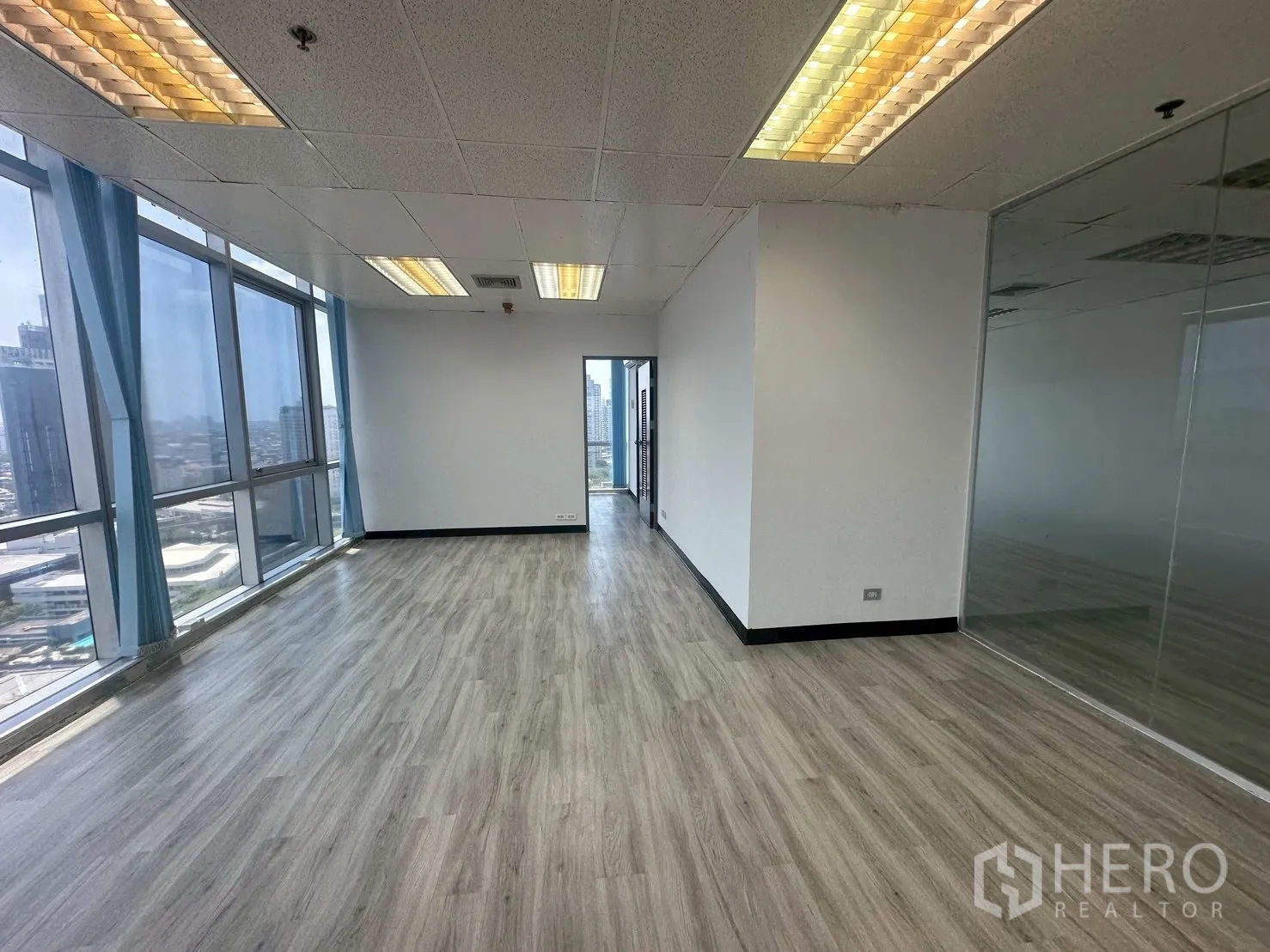 Office Space for rent - Light-filled corner office with glass partitions and sweeping Bangkok views.