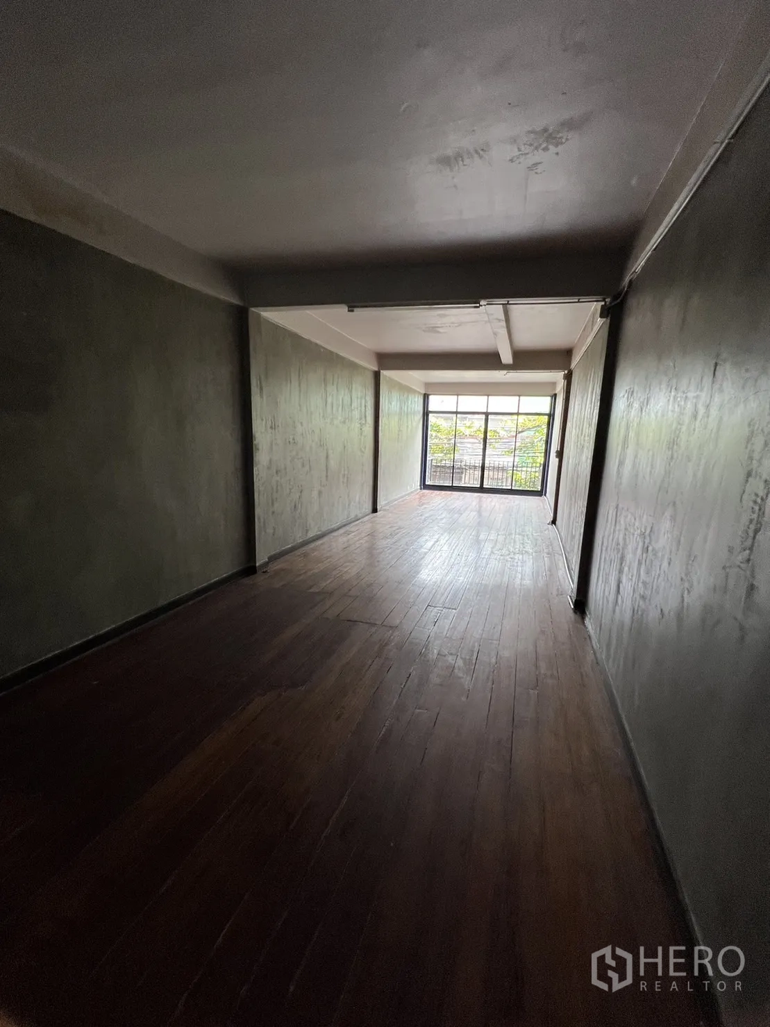 店屋 出租在Watthana, Bangkok - 深进式工作/居住空间，深色木地板，通向阳台的落地门。