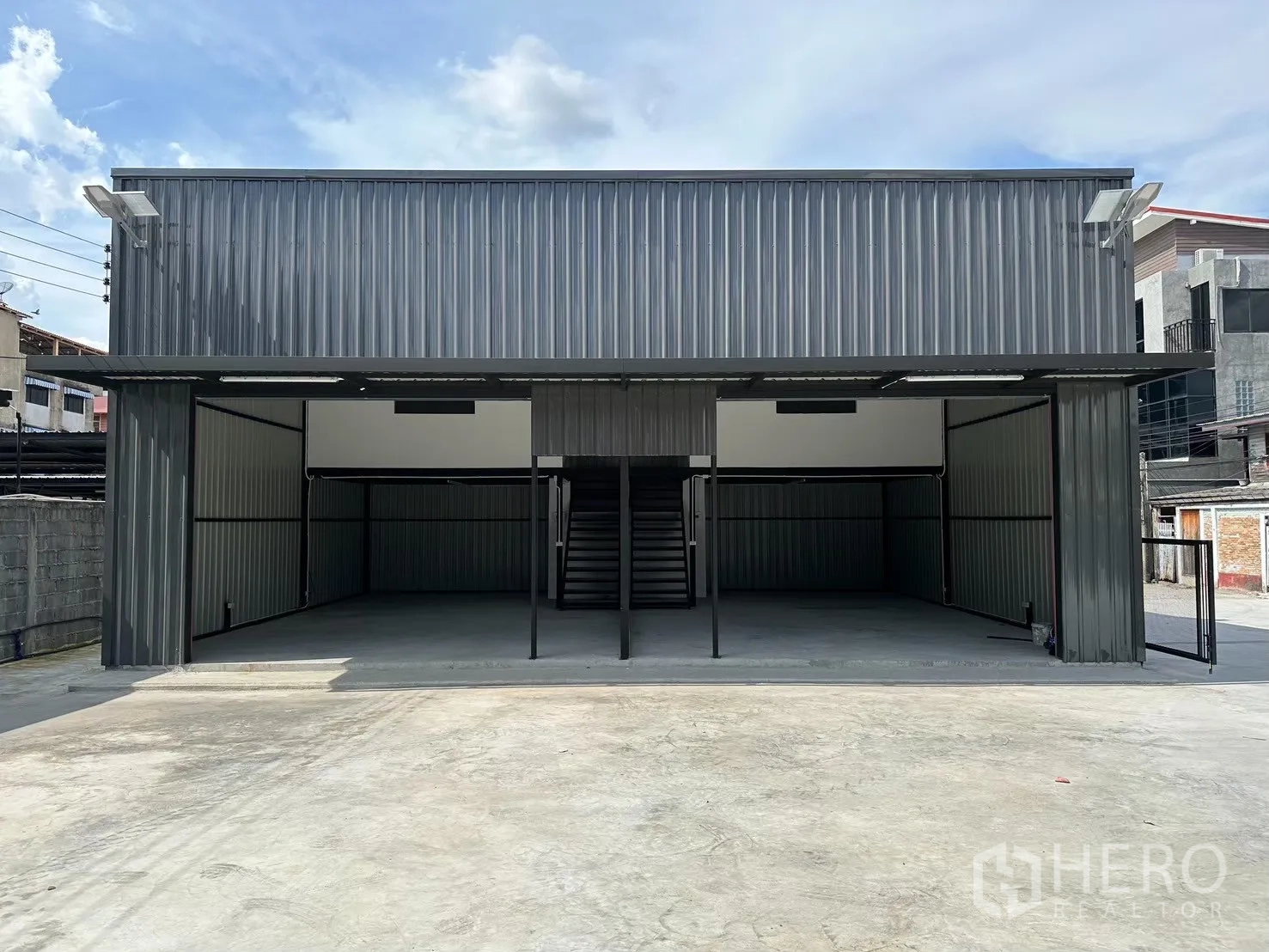 Warehouse for rent in Prawet, Bangkok - Front exterior of metal-clad warehouse with wide open bays and paved loading yard.
