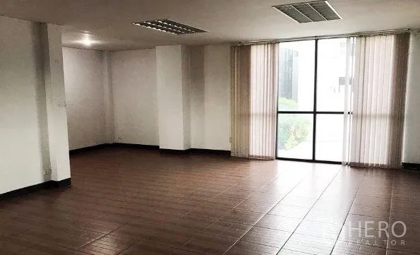 Office Space for rent or sale in Don Mueang, Bangkok - Spacious workspace with wood-look tile flooring and floor-to-ceiling window with vertical blinds.