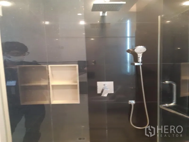 公寓 出租在Khlong Toei, Bangkok - 玻璃淋浴间，配顶喷与手持花洒，深色墙砖。