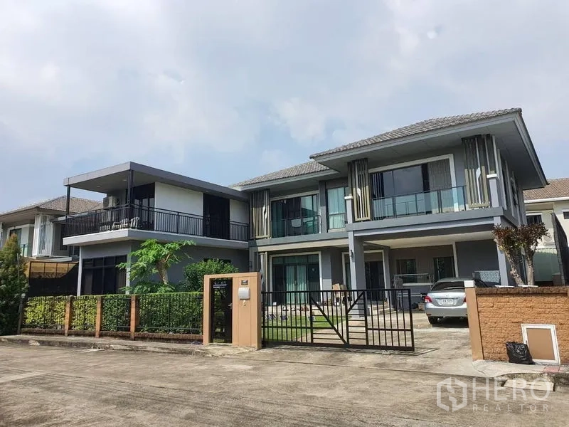 Detached House for sale in Suan Luang, Bangkok - Modern two-storey detached house with gated entrance, carport and glass balconies in a quiet Bangkok community.